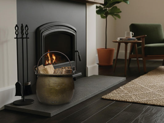 Antique brass cauldron used as a firewood/log holder for vintage home decor.